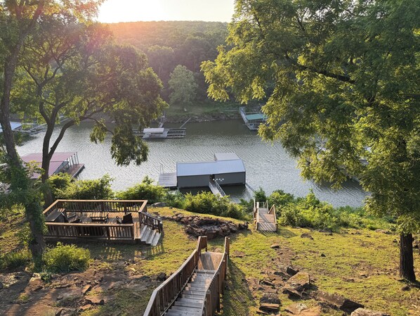 A lakeside property with a dock, wooden deck, and a small building. - The Deckhouse with private boat dock! (Cookson)