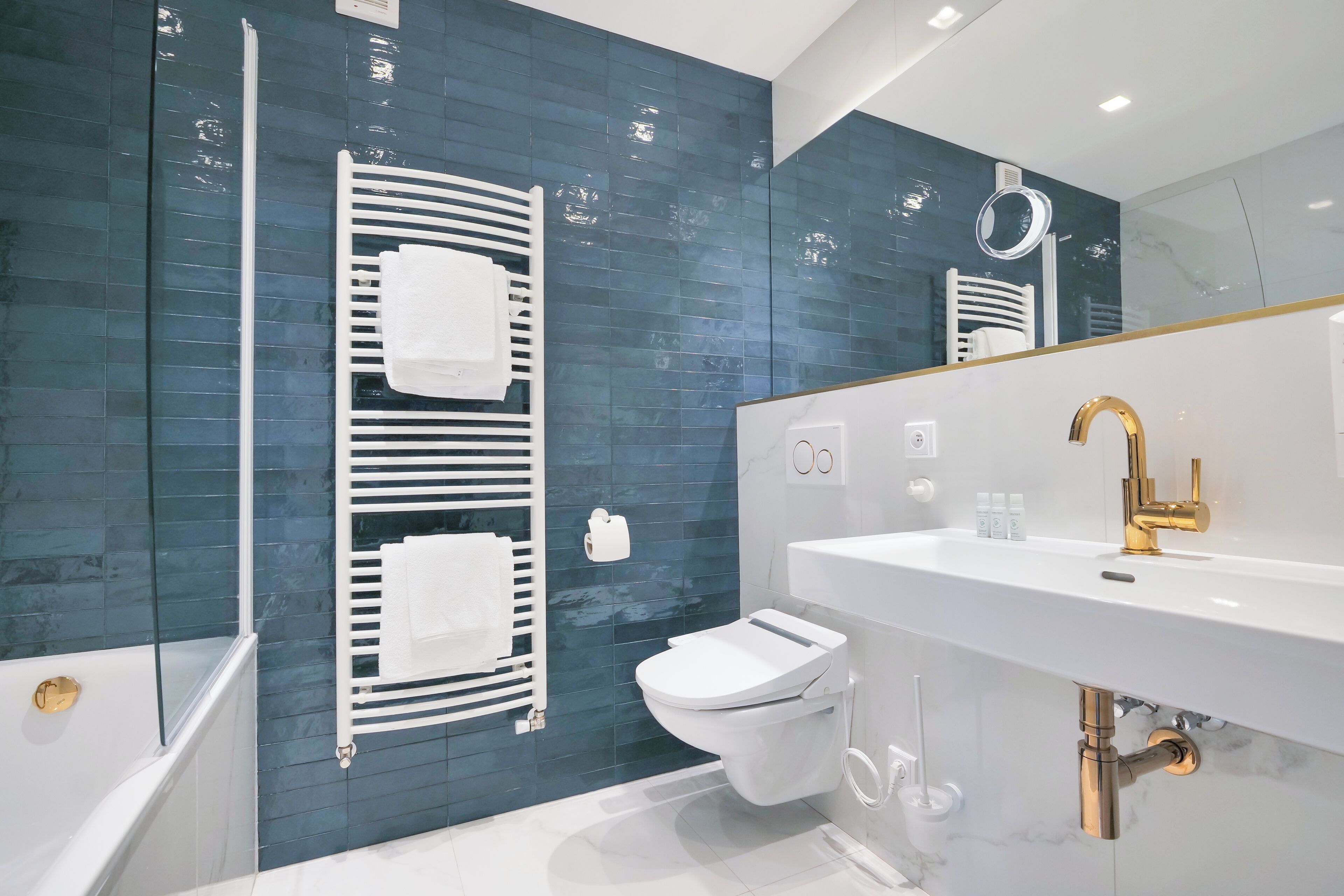 A modern bathroom with a bathtub, toilet, and sink.