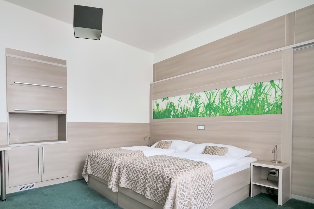 A modern bedroom with a bed, a nightstand, a built-in shelf, and a wall-mounted artwork.