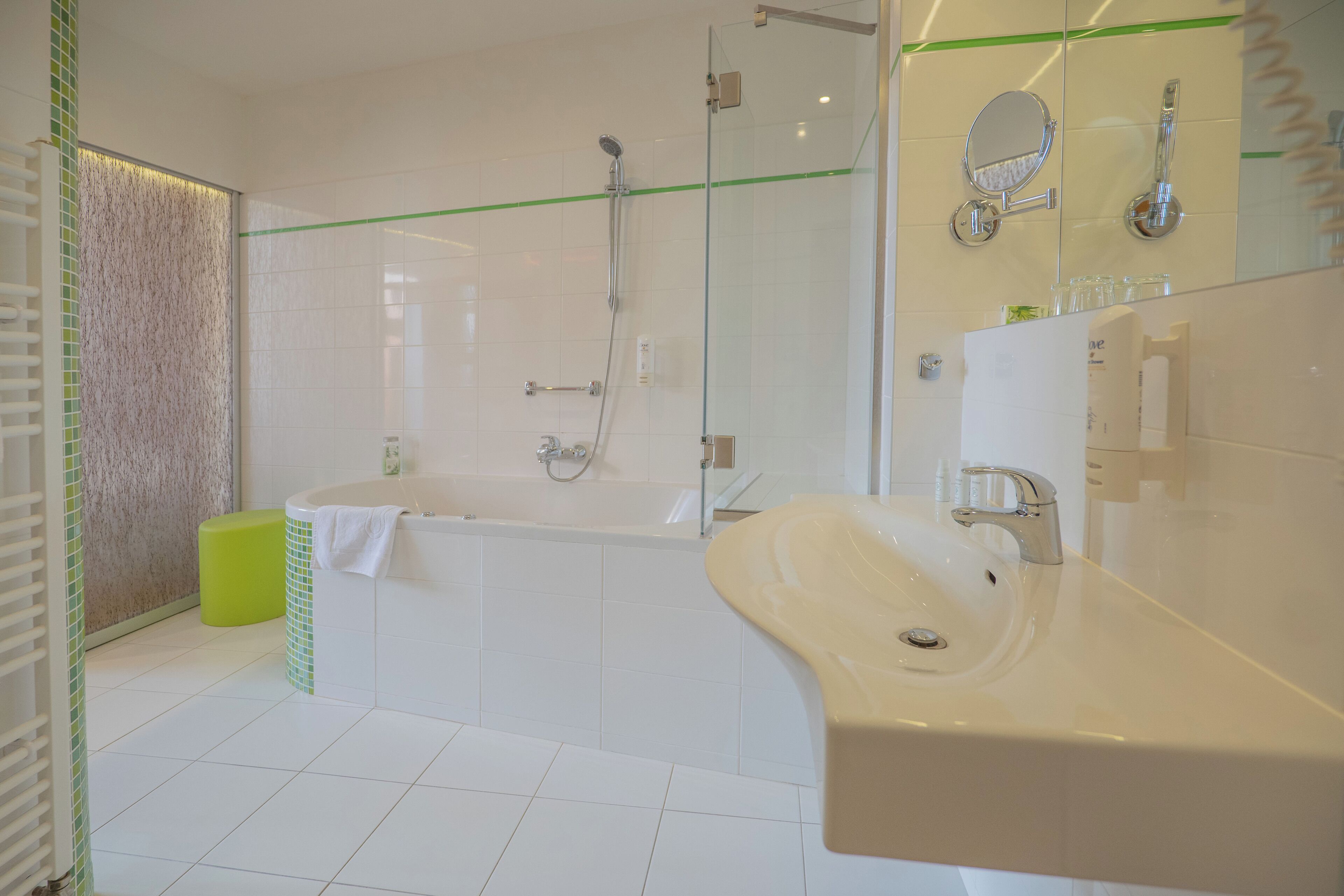 Un baño moderno con bañera, un lavamanos grande y una cabina de ducha de cristal.