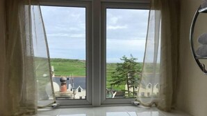 A window with a view of a green landscape and buildings. - 3 Marconi House, Apartment (Crookhaven)