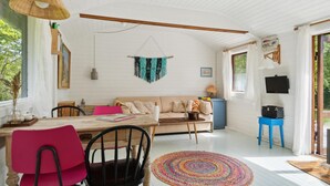 A cozy living room with a wooden dining table, a sofa, and a colorful woven rug. - Stunning home in Askø with kitchen (Askø)