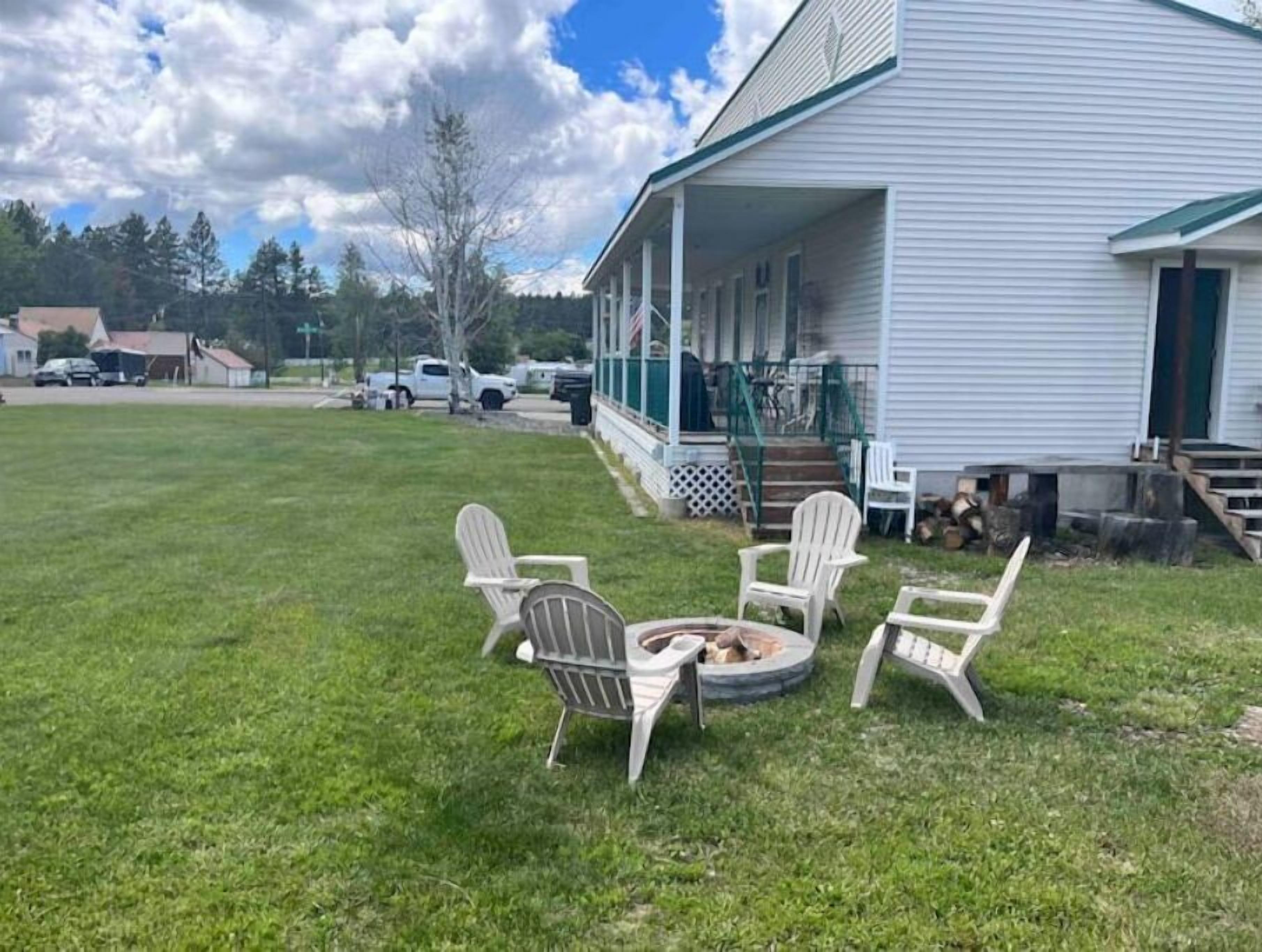 A house with a porch, a fire pit, and outdoor seating.
