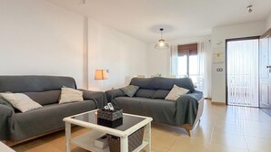 A living room with two grey sofas, a white coffee table, and a hanging light fixture. - 2 bedroom amazing home in Cartagena (Cartagena)