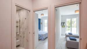 Une chambre d’hôtel avec salle de bain, un lit et un coin salon.