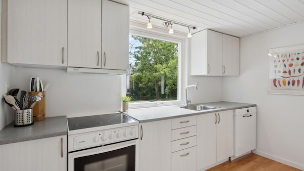 A modern kitchen with white cabinetry, a built-in oven, a stovetop, and a window with a view of greenery. - 2 bedroom gorgeous home in Vordingborg (Vordingborg)