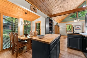 Una cocina moderna con armarios de madera, una isla central y ventanas amplias.