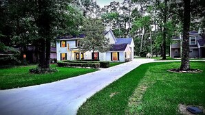 A two-story house with a front porch, a driveway, and a well-maintained lawn.
