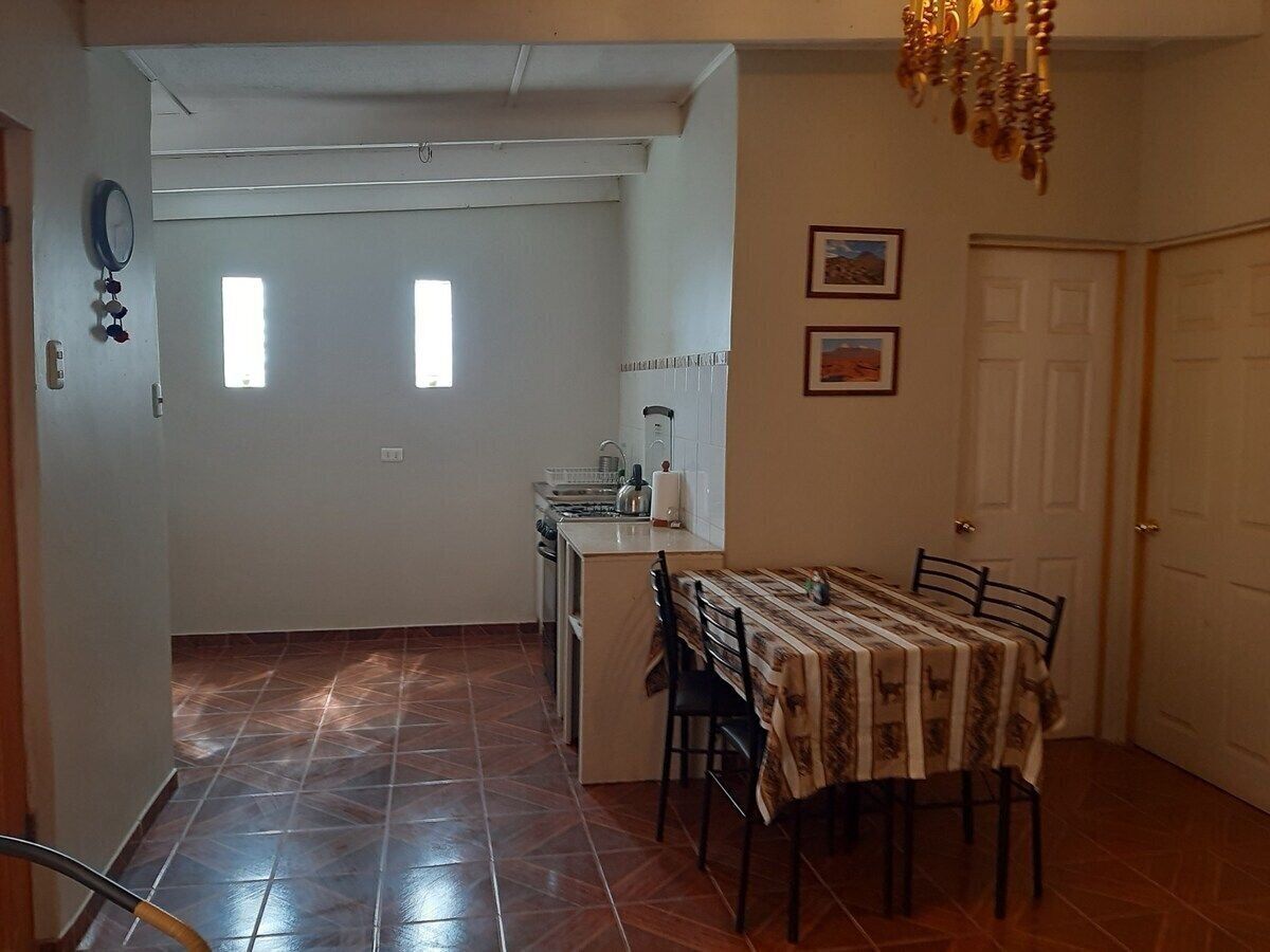A compact kitchen with a dining area, a small island, and a chandelier.