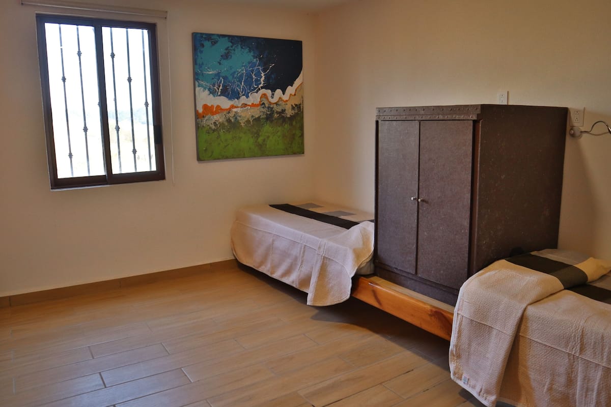 Une pièce comprenant un lit, une armoire et un tableau accroché au mur.