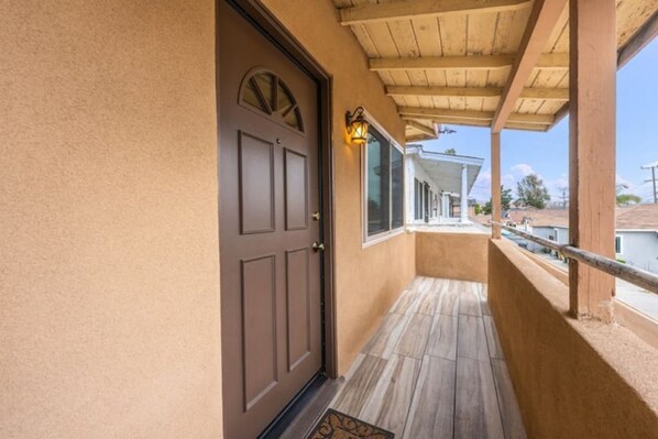Step out onto the covered porch with a door leading to the outdoors.