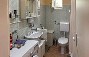 Casa de banho compacta com lavatório, espelho e sanita.
