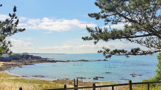 A coastal view with a wooden fence, a sandy beach, and a calm sea. - Beach front home in Clohars-Carnoët with WiFi (Clohars-Carnoët)