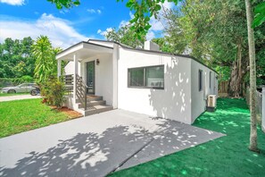 Stroll up to the entrance of this single-story home, surrounded by a lush lawn and trees.
