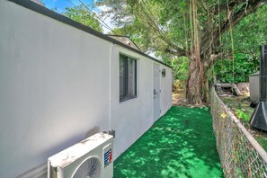 Situated near a large tree, this compact home features a small garage and a landscaped outdoor space.