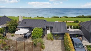 A modern house with a flat roof, a covered patio, and a view of the sea. - 2 bedroom cozy home in Nyborg (Nyborg)