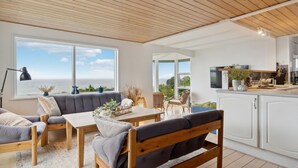 A modern kitchen with white cabinets, a wooden countertop, and a view of the sea. - 2 bedroom cozy home in Nyborg (Nyborg)