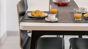 A dining table with a laptop, croissant, and glasses of orange juice. - Lagos Classic by Homing (Lagos)