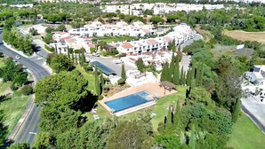 An aerial view of a residential area with a large swimming pool, multiple houses, and surrounding greenery. - Vilamoura Concept Villa With Pool (Loulé)