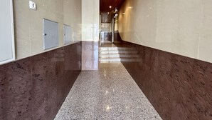 A hallway with a marble floor, wooden ceiling, and a view of a staircase leading to another area. - Armação Pêra Typical by Homing (Silves)