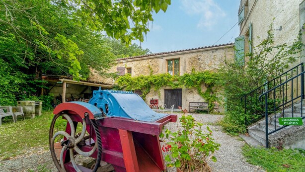 A rustic stone building with a garden area, a vintage blue and red machine, and a sign reading "CHAMBRES D'HOTES". - Awesome home in Chalabre with WiFi (Chalabre)