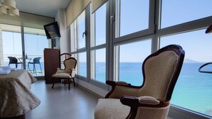 A room with a large window, a bed, two chairs, a TV, and a wooden cabinet. - BAUPRES luxury apartment (Calpe)