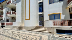 Un edificio con facciata bianca, porte blu e un'area d'ingresso piastrellata.