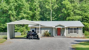 A two-story house with a covered garage and a red door. - Guntersville Lake House: Boat Ramp Access! (Scottsboro)