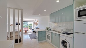 A modern kitchen with a built-in washing machine, a microwave, and a sink. - Quinta DO Lago Victory Village With Pool (Loulé)