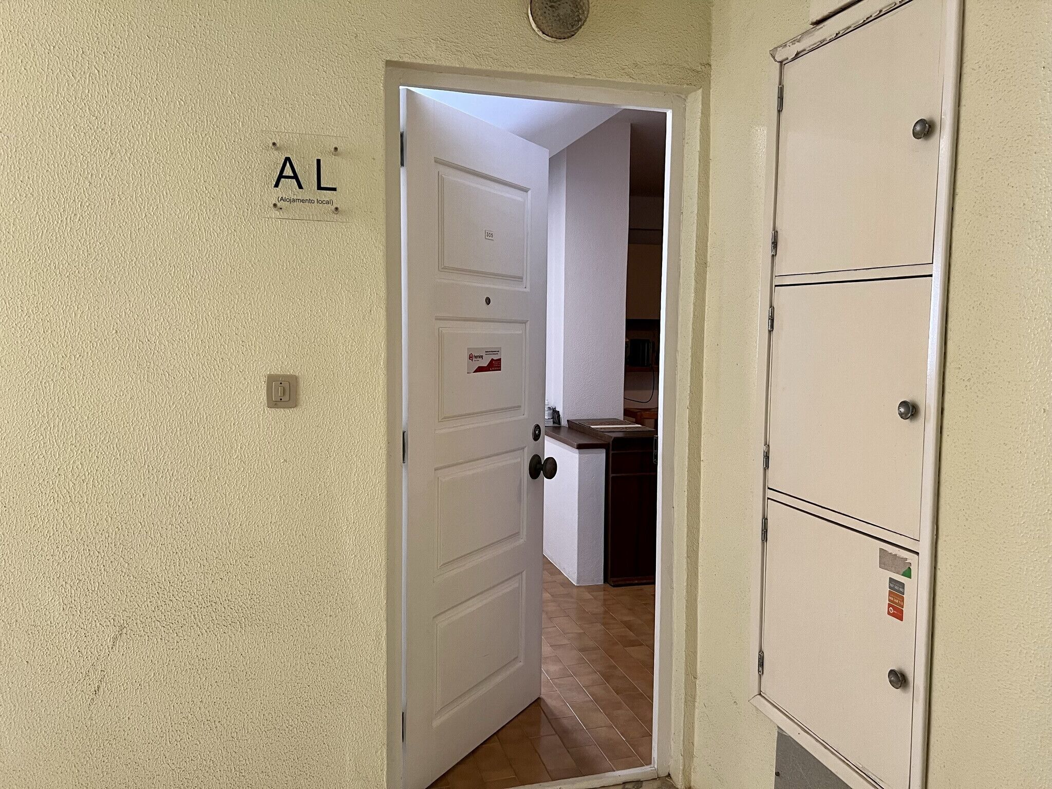 A hallway with a door labeled "AL (Allegamento local)" leading to a kitchen area.