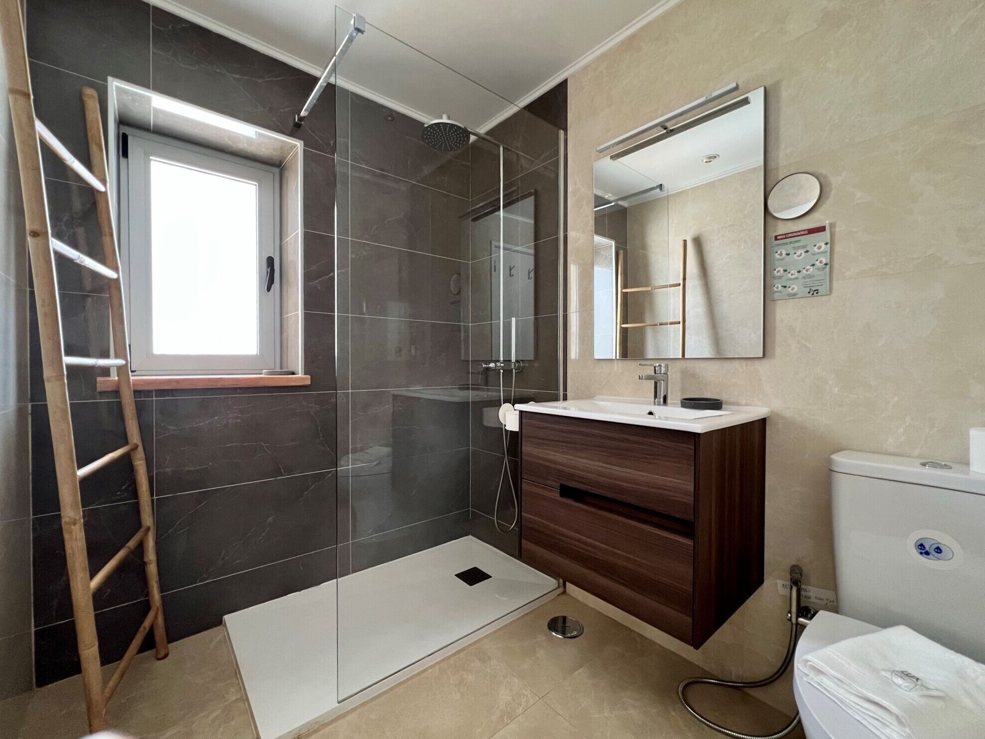 A modern bathroom with a shower, a toilet, and a sink.