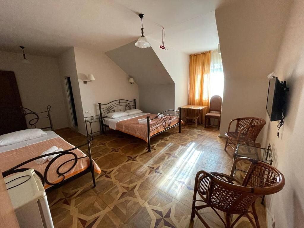 Ein Zimmer mit zwei Betten, einem Esstisch und einem Stuhl.
