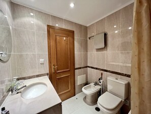 A bathroom with a wooden door, a sink, a bidet, and a toilet. - Albufeira Valley 1 With Pool by Homing (Albufeira)