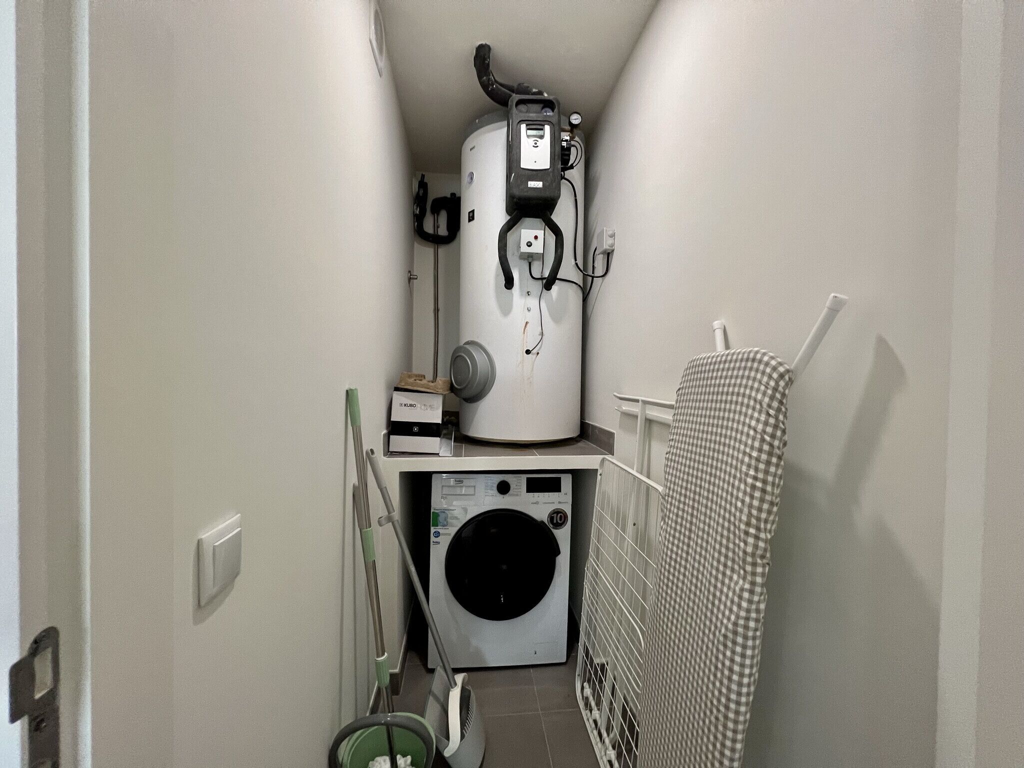 A laundry room with a washing machine, dryer, and stacked laundry baskets.