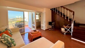 Amplia sala de estar con un sofá, una mesita y vistas al exterior.