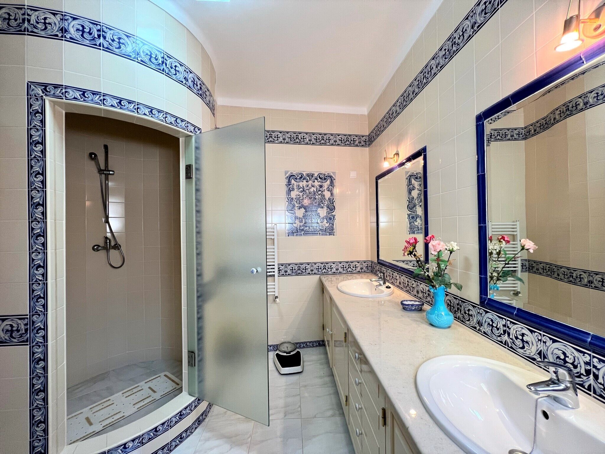 Une salle de bain avec une douche, un lavabo et un grand miroir.