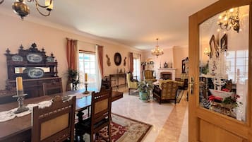 A traditional living room with a fireplace, wooden furniture, and decorative items.