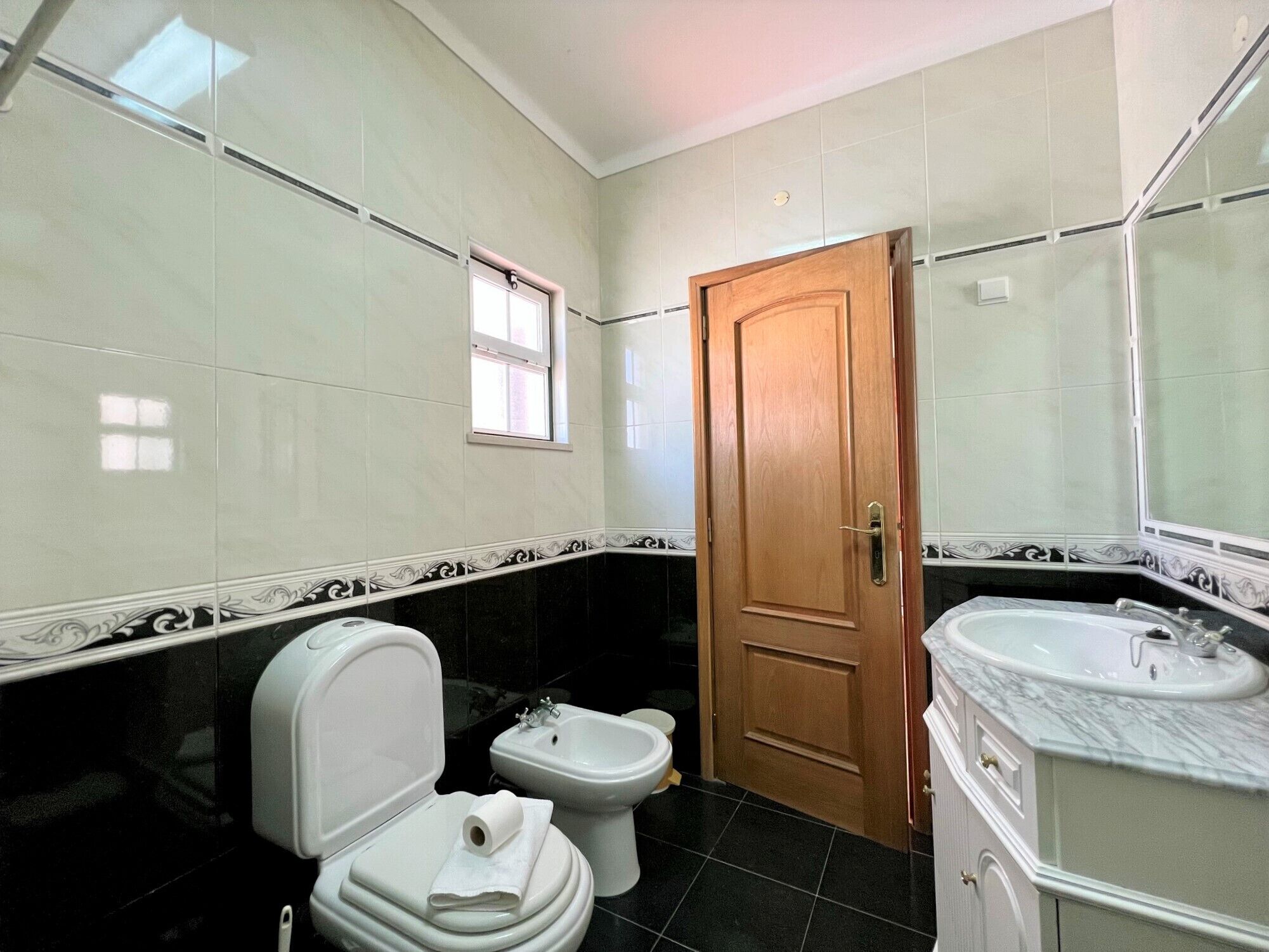 A bathroom with a toilet, bidet, and sink.