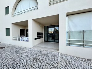 A modern building with a tiled entrance, a glass door, and a metal railing. - Albufeira Salgados Beach 3 by Homing (Albufeira)