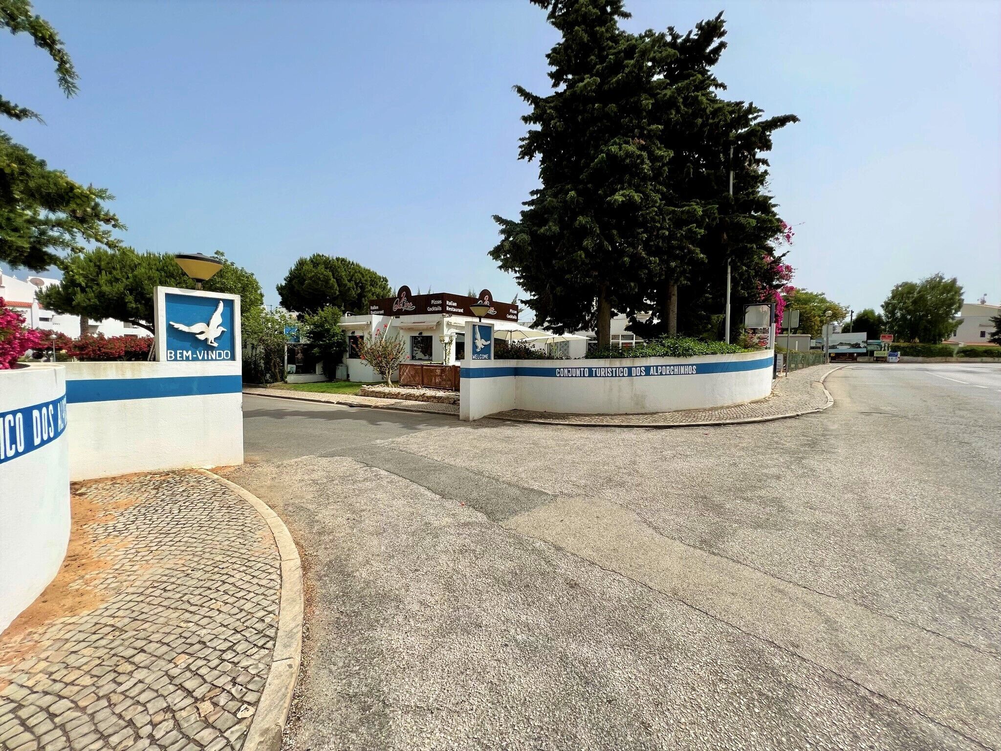 Une route menant à un bâtiment sur lequel on peut lire l’inscription « Bem-Vindo » et « CONJUNTO TURÍSTICO DOS ALPORCHINHOS ».