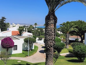A coastal residential area with white buildings, palm trees, and a clear view of the sea. - Armação DE Pêra Brightness 2 With Pool (Lagoa)