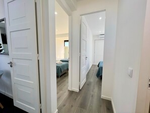 A hotel room with a bed, a bedside table, and a window.