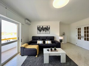 Ein modernes Wohnzimmer mit einer Couch, einem Couchtisch und einem Gemälde an der Wand.