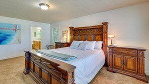 A bedroom with a large bed, wooden headboard, bedside tables, and a carpeted floor. - Pet-Friendly Meridian Vacation Rental w/ Fire Pit! (Meridian)