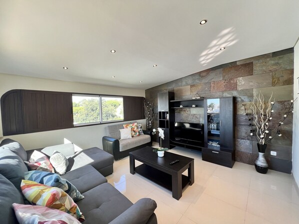 A modern living room with a sofa, coffee table, and entertainment unit.