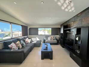 A modern living room with a sofa set, a coffee table, and a built-in entertainment unit. - Quarteira Classic With Pool by Homing (Loulé)