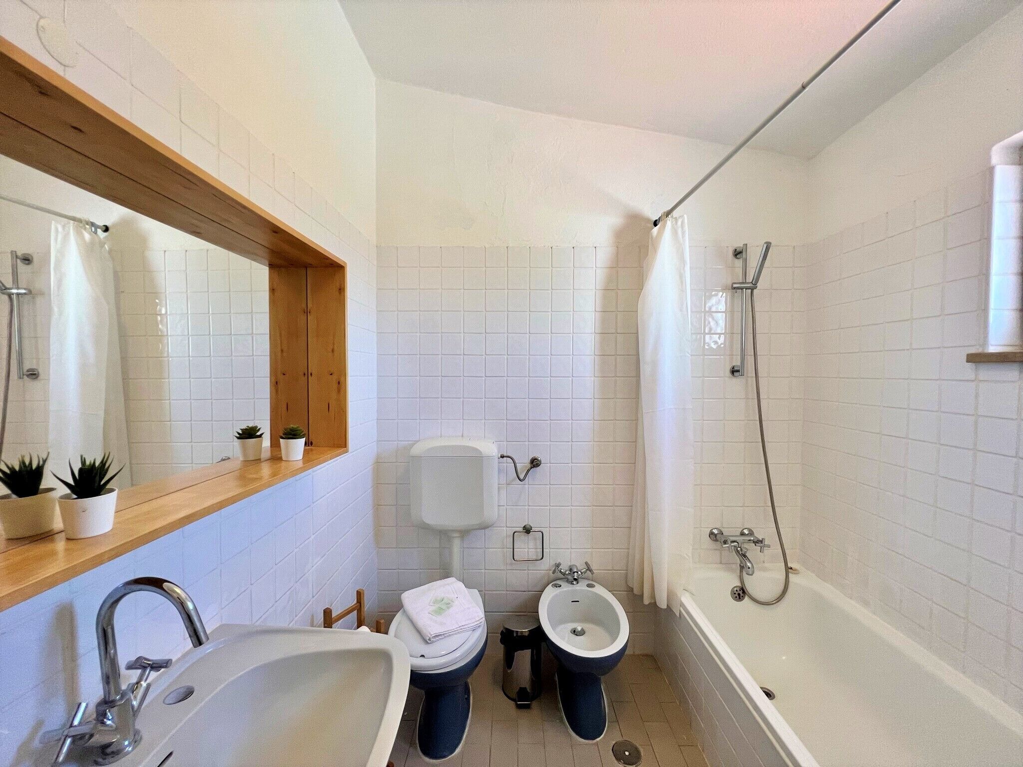 Ein Badezimmer mit Waschbecken, Toilette, Bidet und Badewanne.