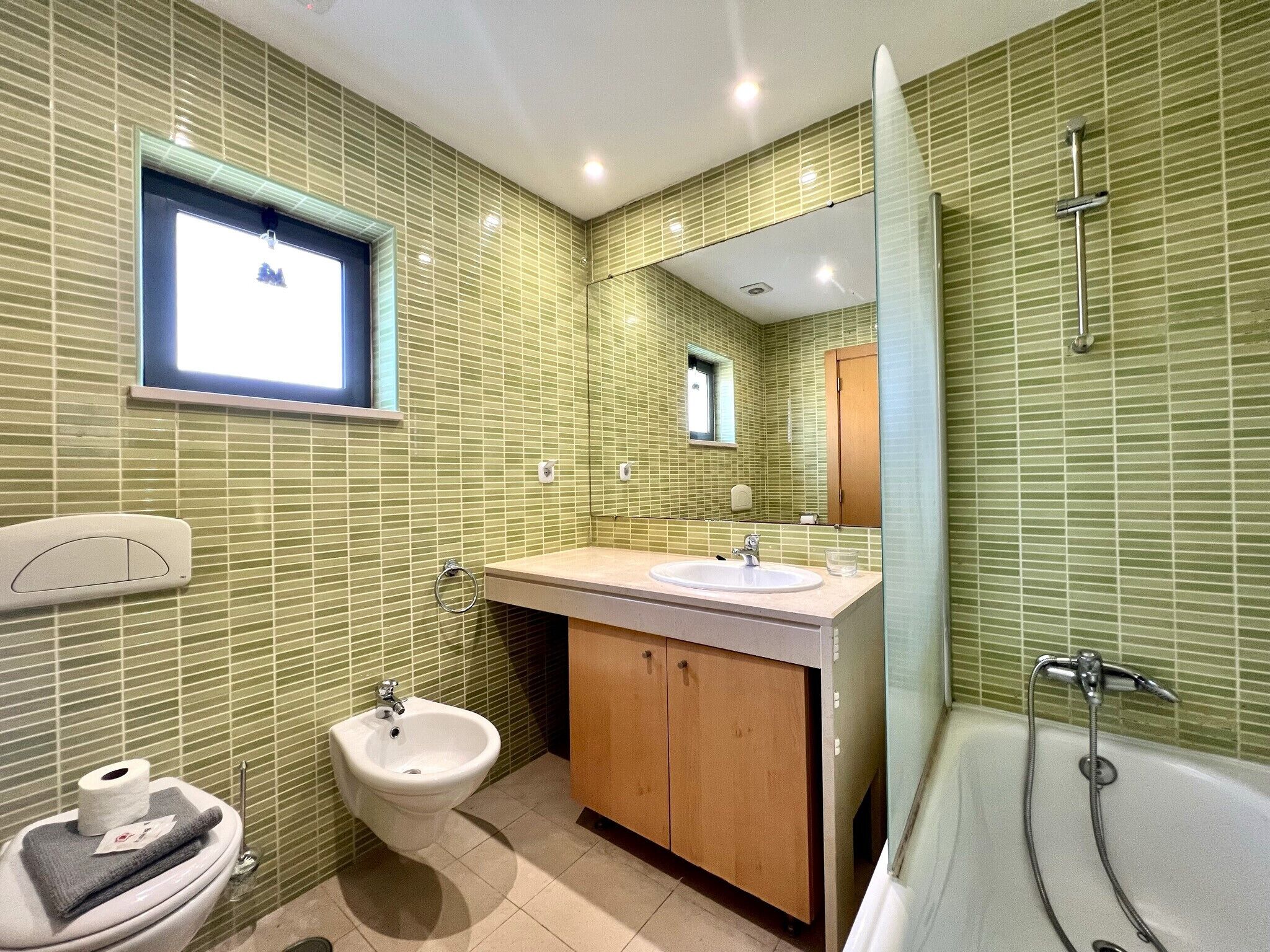 Un bagno con bidet, lavabo e vasca da bagno.