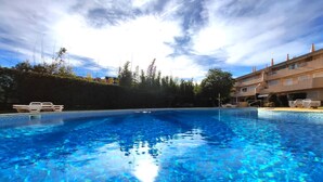 A clear blue swimming pool with lounge chairs and a building in the background. - Vilamoura Typical 2 With Pool by Homing (Loulé)