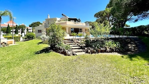 A two-story house with a swimming pool, surrounded by a well-maintained lawn and various plants. - Vilamoura Amazing Golf Villa With Pool (Loulé)